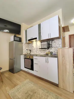 a kitchen with white cabinets and stainless steel appliances at Charming Studio 88 in Bansko