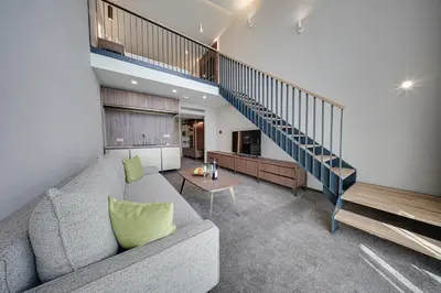 a living room with a couch and a staircase at Hotel Complex SamElyon in Samokov