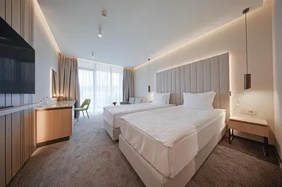 a hotel room with two beds and a desk at Hotel Complex SamElyon in Samokov