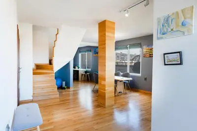 a living room with a staircase and a table and chairs at Luna Penthouse Stunning Sofia Skyline plus FREE Parking in Sofia