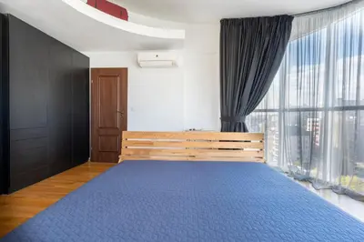 a bedroom with a blue bed and a large window at Luna Penthouse Stunning Sofia Skyline plus FREE Parking in Sofia