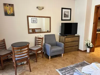 a living room with a tv and a table and chairs at St Ivan Rilski Spa & Pool Getaway in Bansko