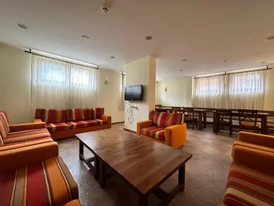 a waiting room with couches and a table and a tv at St Ivan Rilski Spa & Pool Getaway in Bansko