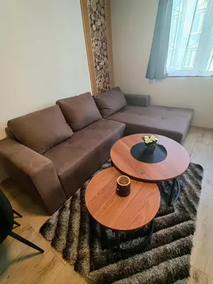 a living room with a brown couch and two tables at Sunny Mountain View Villa Kometa in Pamporovo