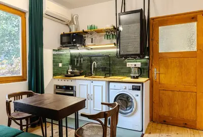 a kitchen with a washing machine and a table at Paganini House close to Center and Rowing Canal in Plovdiv