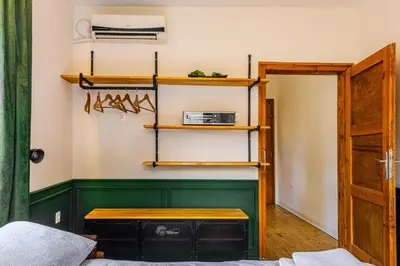 a room with a green wall with shelves and a table at Paganini House close to Center and Rowing Canal in Plovdiv
