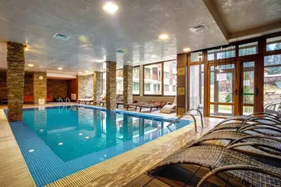 a large swimming pool in a hotel room at Captain's Apartment in Pamporovo