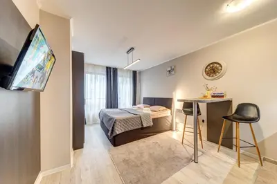 a small room with a bed and a table and a television at Studio in Dream View Resort in Pamporovo