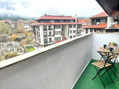two chairs on a balcony with a view of a city at Two Modern Apartments in One Building by SI Stay in Bansko