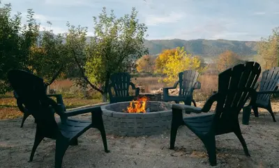 a group of chairs sitting around a fire pit at Guest house by the river in Simitli