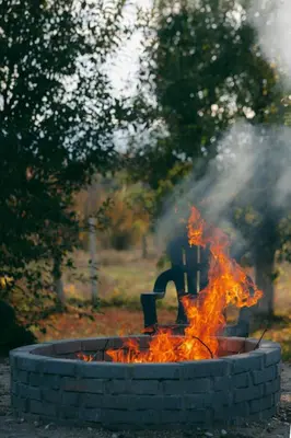a fire pit with smoke and flames in it at Guest house by the river in Simitli