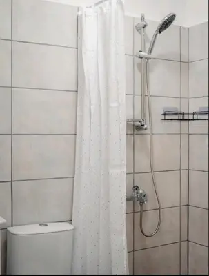 a bathroom with a shower with a white shower curtain at Guest house by the river in Simitli