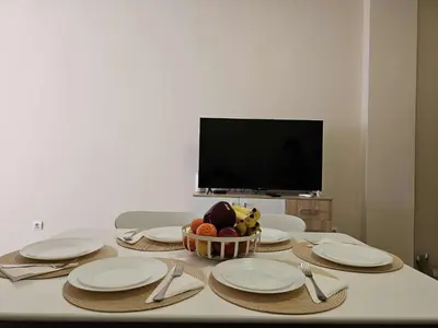 a table with plates and a bowl of fruit on it at Apartment Bee Happy, Pchelinski Bani,Hot mineral water in Pchelin