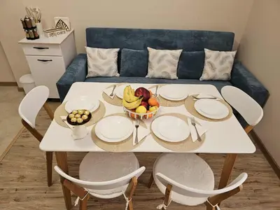 a table with plates and a bowl of fruit on it at Apartment Bee Happy, Pchelinski Bani,Hot mineral water in Pchelin