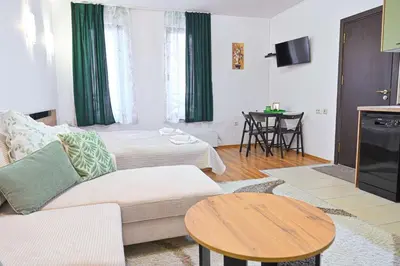 a living room with a couch and a table at Apartment Breath - Peaceful Stay Near Gondola Lift by Flat Mаnаger in Bansko