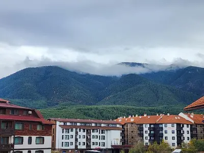 a city with buildings and mountains in the background at Apartment Viktoria near ski lift on Pirin street in Bansko