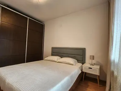 a bedroom with a large bed and a night stand at Apartment Viktoria near ski lift on Pirin street in Bansko