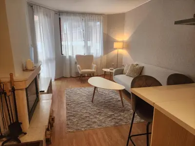 a living room with a couch and a table at Apartment Viktoria near ski lift on Pirin street in Bansko