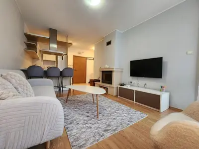a living room with a couch and a flat screen tv at Apartment Viktoria near ski lift on Pirin street in Bansko