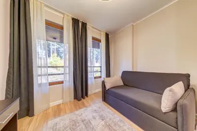 a living room with a couch and two windows at Alpine Escape at Dream View in Pamporovo