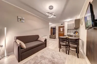 a living room with a couch and a kitchen at Ski Slope Retreat at Dream View in Pamporovo