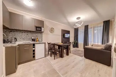 a kitchen and living room with a table and a couch at Ski Slope Retreat at Dream View in Pamporovo