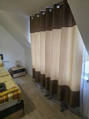 a bedroom with a bed and a curtain at Stylish 1BR near Centre in Sofia