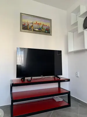 a flat screen tv sitting on a red entertainment center at Stylish 1BR near Centre in Sofia