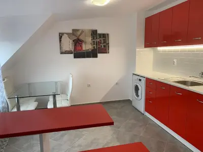 a kitchen with red cabinets and a washing machine at Stylish 1BR near Centre in Sofia