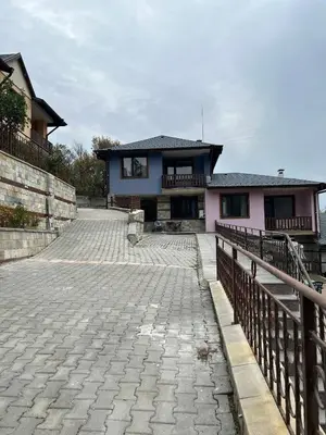 a house with a stone driveway in front of it at Семеен хотел Струма in Boboshevo