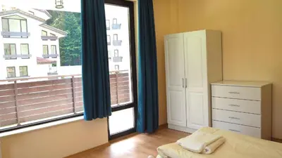 a bedroom with a large window and a dresser at Elit Pamporovo Apartments in Pamporovo