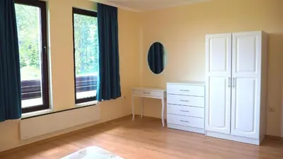 a bedroom with a white dresser and two windows at Elit Pamporovo Apartments in Pamporovo
