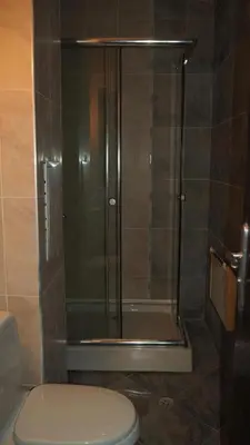 a shower in a bathroom with a toilet and a glass door at Elit Pamporovo Apartments in Pamporovo