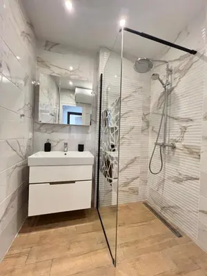 a bathroom with a shower and a sink and a mirror at Marrakech Central 2BDR w Huge Terrace near Serdika in Sofia