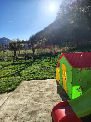 a green and yellow toy house on a playground at Вила Владислава - стаи за гости in Cherni Vit