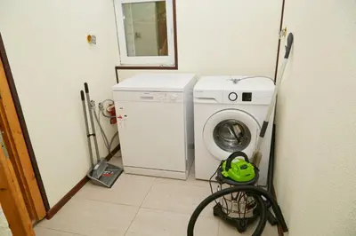 a laundry room with a washing machine and a washer at Вила Владислава - стаи за гости in Cherni Vit