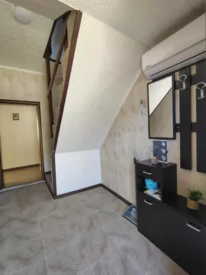 a living room with a staircase and a mirror at Вила Владислава - стаи за гости in Cherni Vit