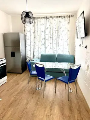 a living room with a table and blue chairs at Atelier-apartament in Sandanski