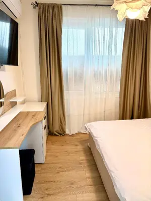 a bedroom with a bed and a desk and a window at Atelier-apartament in Sandanski