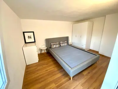 a bedroom with a large bed and a wooden floor at Small Bijou on the rooftop in Sofia