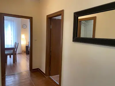 a hallway with a mirror and a door with a table at Cedar Lodge Apartament - Gondola in Bansko