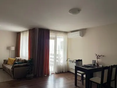 a living room with a couch and a table and a window at Comfortable and affordable big studio in Bansko