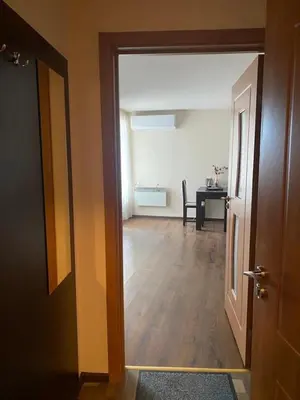 a hallway with a room with a table and a door at Comfortable and affordable big studio in Bansko