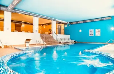 a swimming pool in a building with blue walls at Forestside Stay at Stream Resort in Stoykite