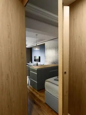 a room with a bed and a kitchen in the background at Sofia Central View Loft in Sofia
