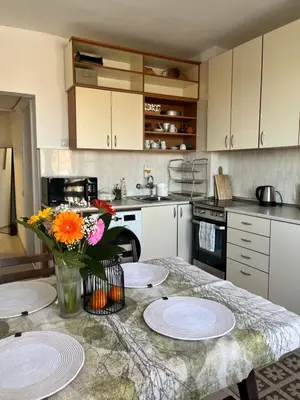 a kitchen with a table with plates and flowers on it at Cosy home in the heart of Bansko in Bansko