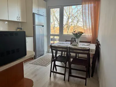 a kitchen with a table with chairs and a refrigerator at Cosy home in the heart of Bansko in Bansko