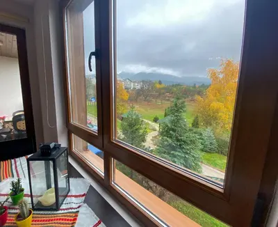 a window with a view of a field and trees at Green Life Private Apartment D27 in Bansko