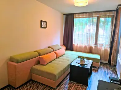 a living room with a couch and a table at Warm Evenings and free Bottle of Wine in Perun Lodge in Bansko
