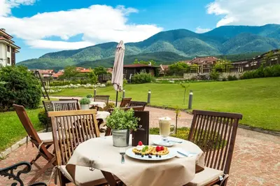 a table with a plate of food on a patio at Warm Evenings and free Bottle of Wine in Perun Lodge in Bansko